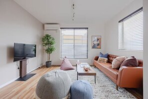 A living room with a flat-screen TV, a sofa, a coffee table, and a potted plant. - Home in Sangenjaya, Tokyo | 2 Stops to Shibuya (世田谷区)