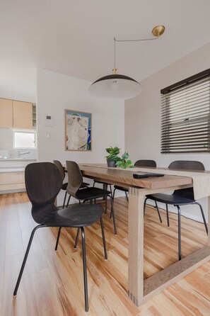 A modern dining area with a wooden table, black chairs, and a pendant light. - Home in Sangenjaya, Tokyo | 2 Stops to Shibuya (世田谷区)