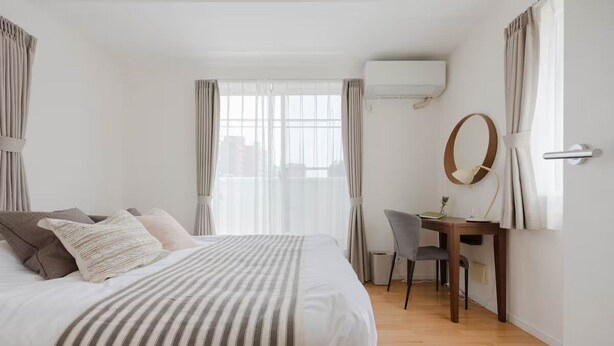 Hotellihuone, jossa on sänky, työpöytä ja tuoli.