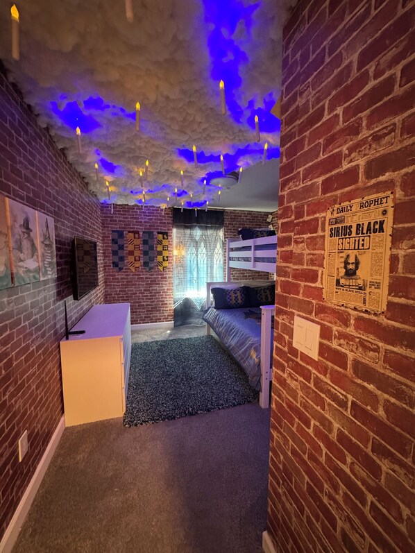 A room with brick walls, a bunk bed, a desk, and a ceiling with blue lighting. - 4BR/3BA Townhouse w/ Private Pool in Storey Lake (Kissimmee)