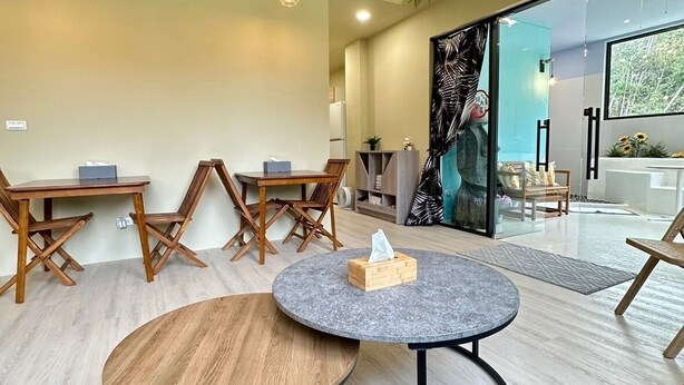 Un intérieur moderne avec des tables rondes, des chaises en bois et une grande fenêtre donnant sur un paysage.