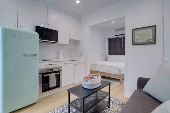 Living area with a view of the kitchen and bed area. 