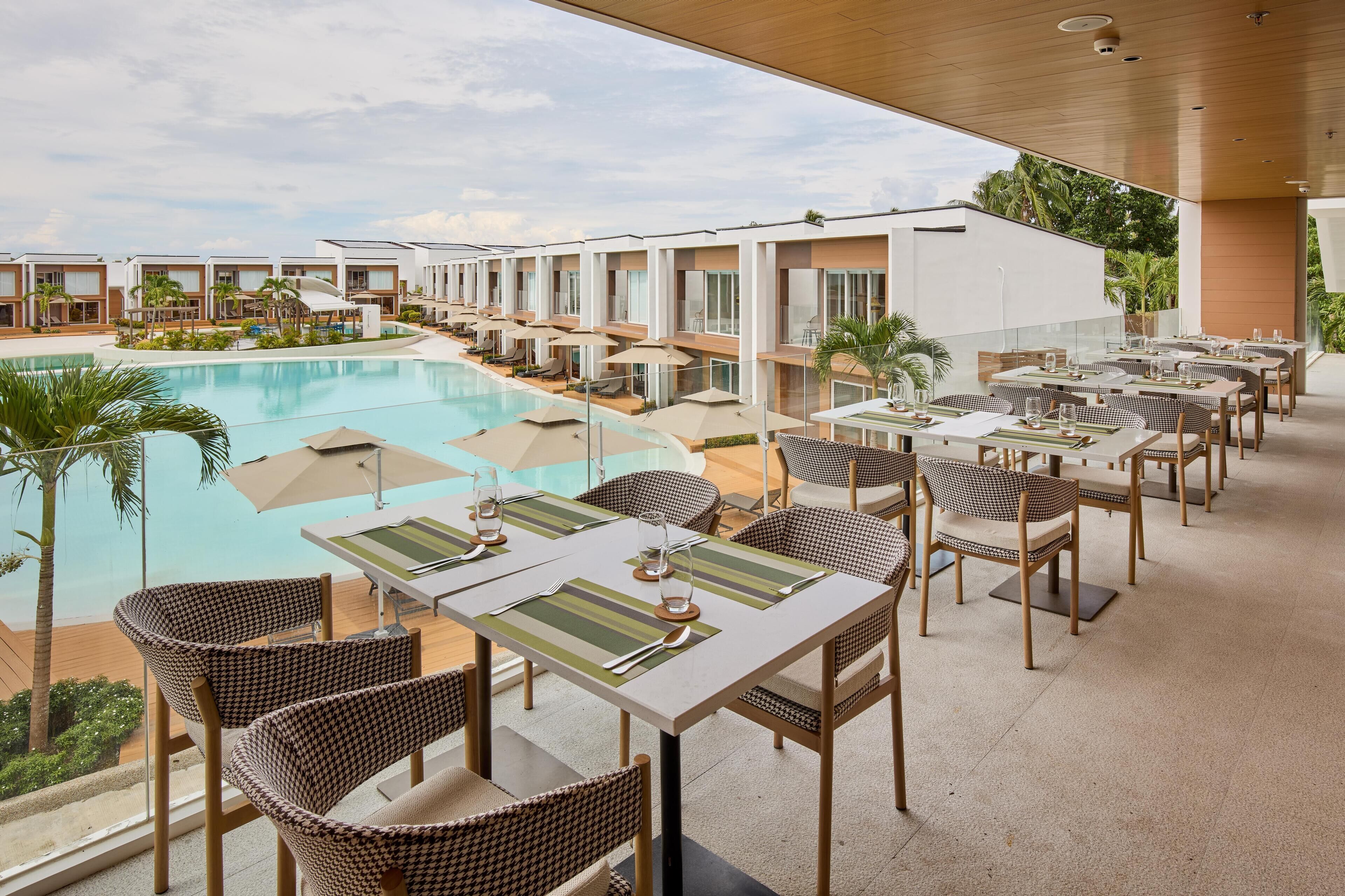 Un espace aménagé au bord de la piscine, avec des sièges extérieurs et une vue sur la piscine.