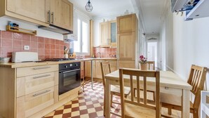 Una cocina compacta con armarios de madera, una estufa a gas y piso a cuadros.