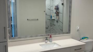 Chuveiro, toalhas de banho, sabonete, papel higiênico