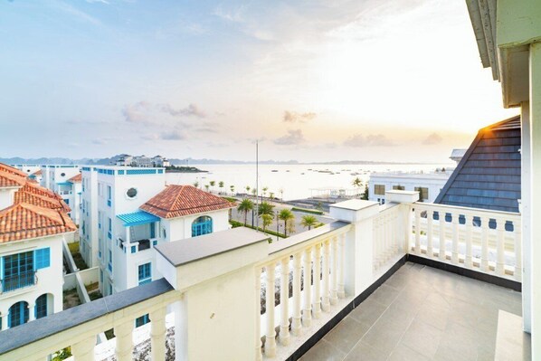 A rooftop terrace with a view of the sea and buildings. - Indotel Ha Long Hotel (Ha Long)