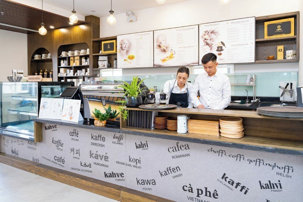 A cafe with a counter, menu boards, and a coffee machine.