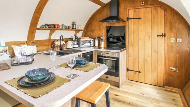 A compact kitchen with wooden cabinetry, a built-in oven, and a sink.