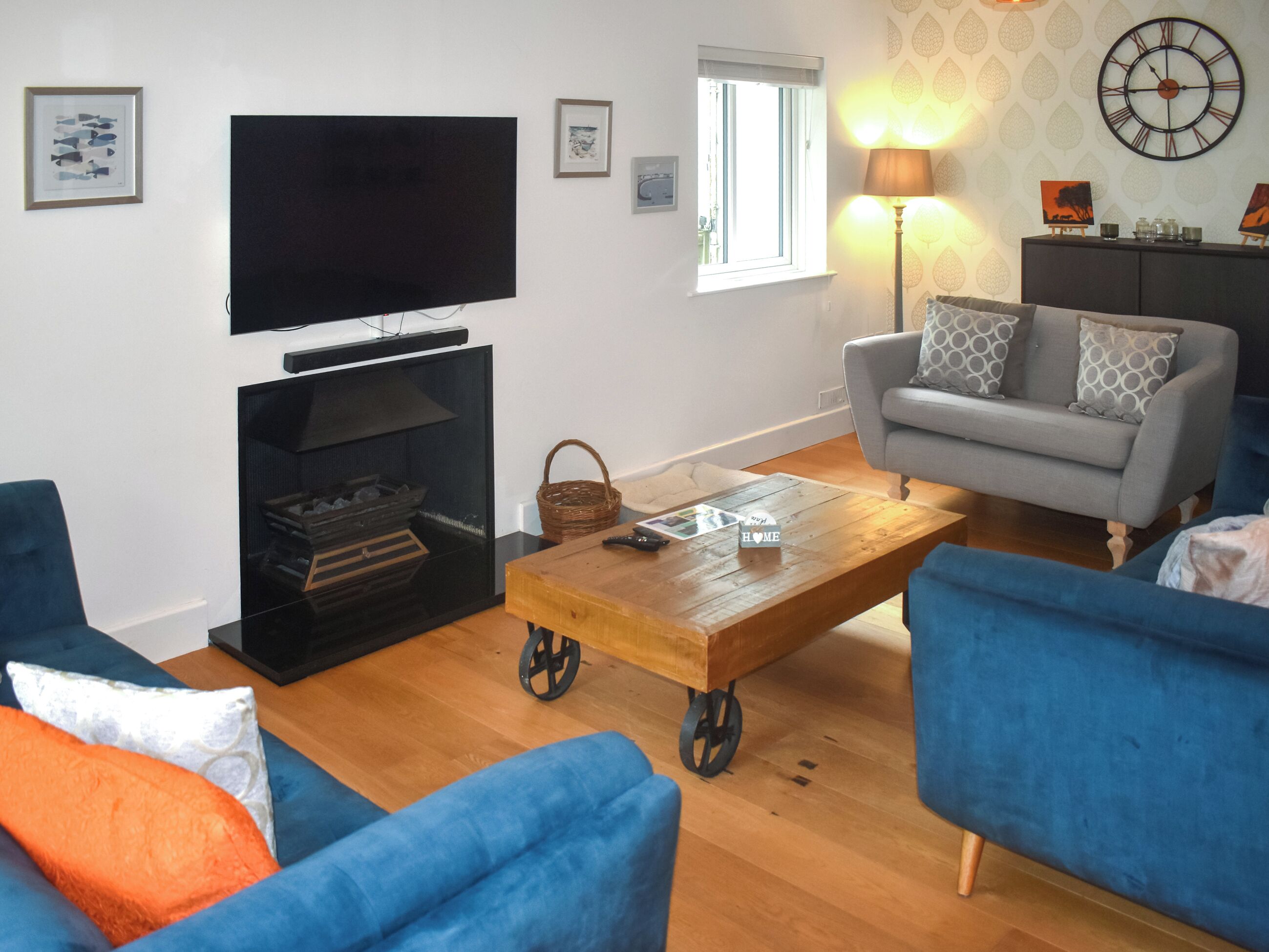 A living room with a flat-screen TV, a fireplace, a sofa, and a coffee table.