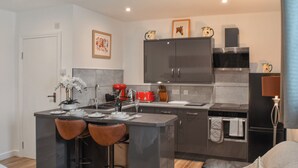 Una cocina moderna con una isla central, taburetes de bar y una zona de comedor.