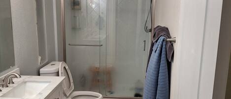Een douche, handdoeken, zeep, toiletpapier