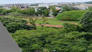 A view of a residential area with trees and buildings. - Serene Legacy Park View (Mysore)