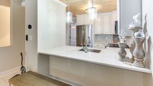 A modern kitchen with a large island, stainless steel appliances, and pendant lighting. - Boat, Fish & Walk to Beach: Waterfront Destin Gem! (Destin)