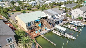 A waterfront property with a dock, boats, and a large building with a green roof. - Boat, Fish & Walk to Beach: Waterfront Destin Gem! (Destin)