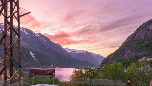 Una vasca idromassaggio con vista sulle montagne, candele e una bottiglia di champagne.