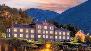 Un grande edificio a più piani con facciata simmetrica, numerose finestre e un ingresso centrale.