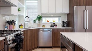 Una cocina moderna con lavavajillas, estufa y refrigerador.
