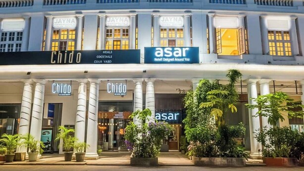 A hotel facade with 'Chido' and 'asar' signage, featuring a classical architectural style with columns and a well-lit entrance. - asar CP Outer Circle by Orion Hotels (New Delhi)