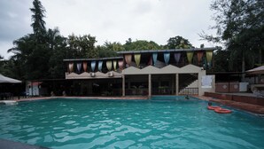 A swimming pool with a covered area and a staircase leading to an upper deck.