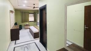 A hotel corridor with a bed, a desk, and a wardrobe. - Hotel Al Aziz (Ajmer)