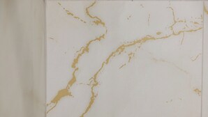 Een witte muur met gouden accenten.