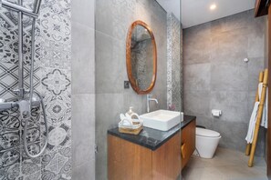 Un baño moderno con una bañera independiente, un lavabo, un espejo y un inodoro.