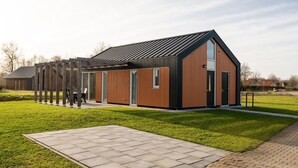 Un bâtiment moderne doté d’un toit en pente et de grandes fenêtres.