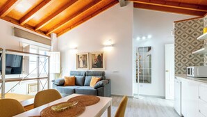 A modern interior with a dining area, a sofa, and a kitchen. - Virgen de la Luz. 2-bedrooms, 2-bathrooms (Sevilla)
