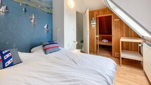 A bedroom with a bed, a wooden wardrobe, and a view of sailboats on the water. - Water villa with outdoor spa, jetty (Eernewoud)