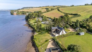 A coastal property with a large house, a private beach, and rolling hills in the background. - Gable View (Combeinteignhead)