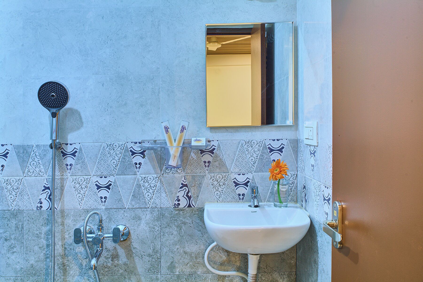 A bathroom with a shower, sink, and mirror.