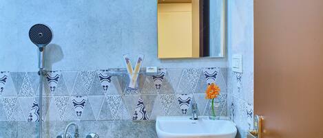 A bathroom with a shower, sink, and mirror.