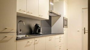 A modern kitchen with a stainless steel sink, a coffee maker, and a microwave. - Spacious comfort stay for couple (Bruinisse)