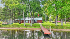 A lakeside cabin with a dock, surrounded by trees and a picnic area. - 4-Season Fun! Sandy Beach | Snowmobile Trails (Couderay)