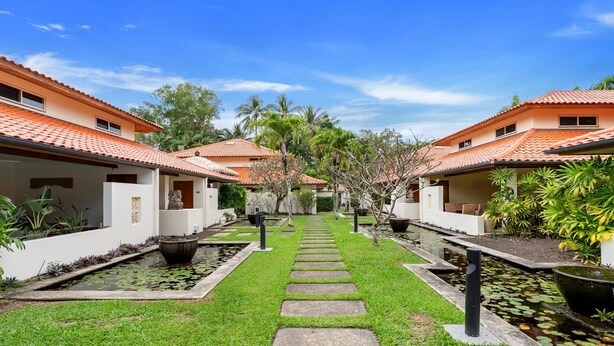 A courtyard with two-story buildings, a central pathway, and water features.