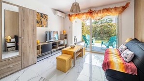 A modern living room with a TV, sofa, and dining area. - Modern studio - AC - 2P - Cannes (Cannes)