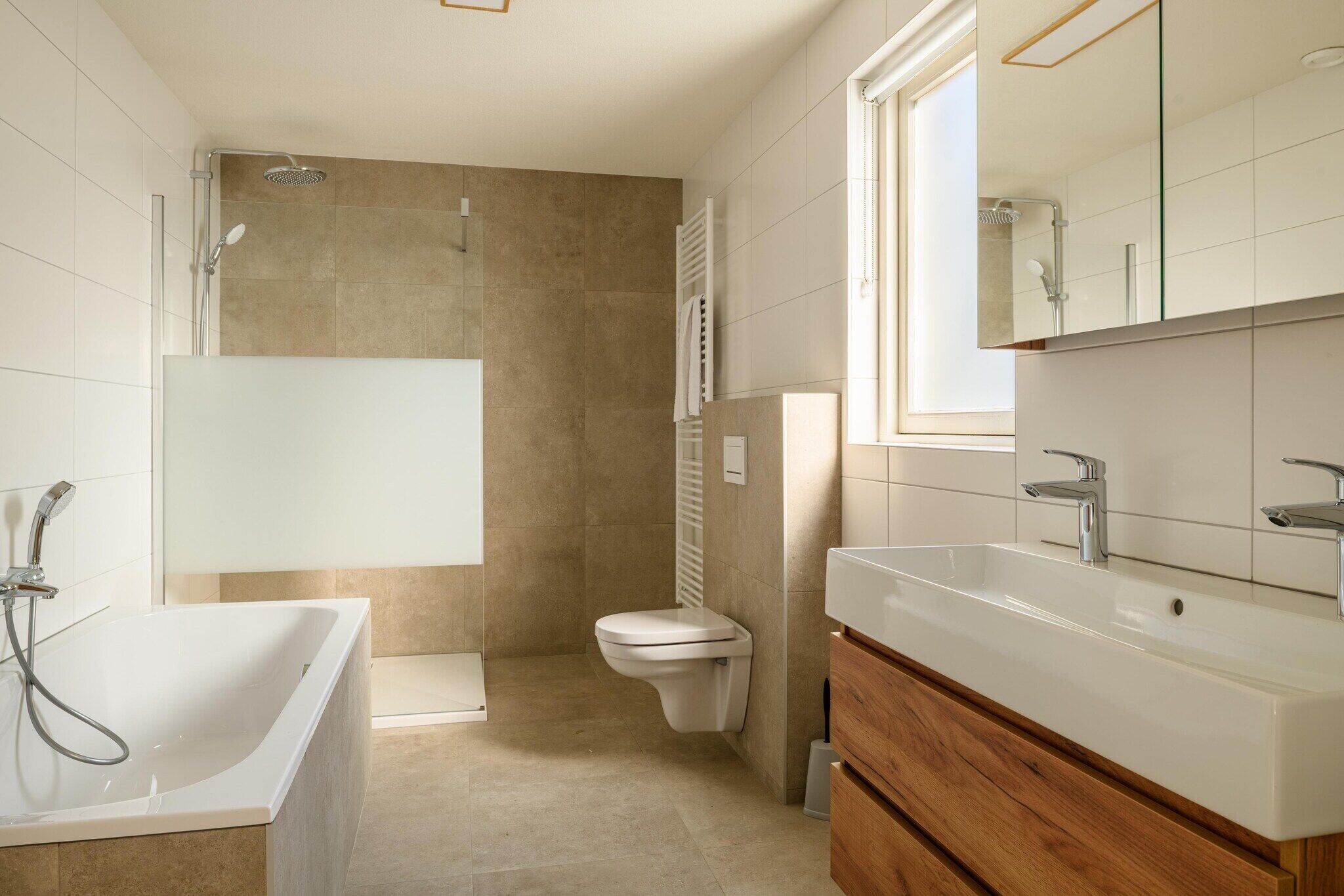 Une salle de bain moderne équipée d’une baignoire, de toilettes et d’une douche.
