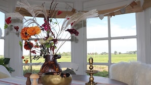 A table with a vase of flowers, a brass bowl, and a candle holder. - Beautifully styled apartment (Betgummole)