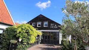 A black building with a sign reading "BY MOSK" and a large glass entrance. - Beautifully styled apartment (Betgummole)