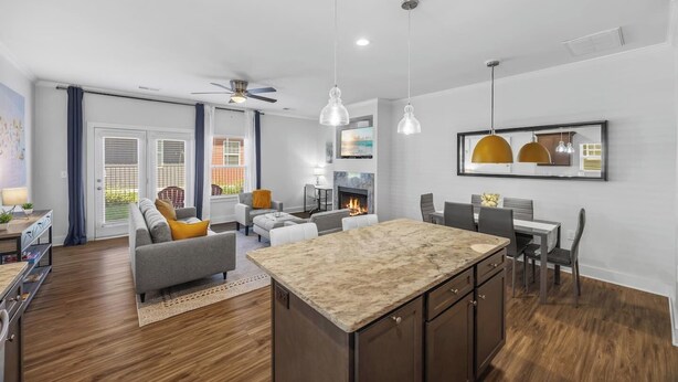 Une cuisine moderne dotée d’un îlot central, de meubles en bois et de luminaires suspendus.