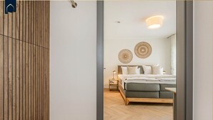 A bedroom with a bed, bedside tables, and decorative wall art. - Löning 1 - Modern vacation home with sauna, terrace & WLAN - close to the beach on Usedom (Ückeritz)
