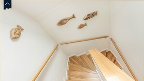A wooden staircase with white walls and a handrail. - Löning 1 - Modern vacation home with sauna, terrace & WLAN - close to the beach on Usedom (Ückeritz)