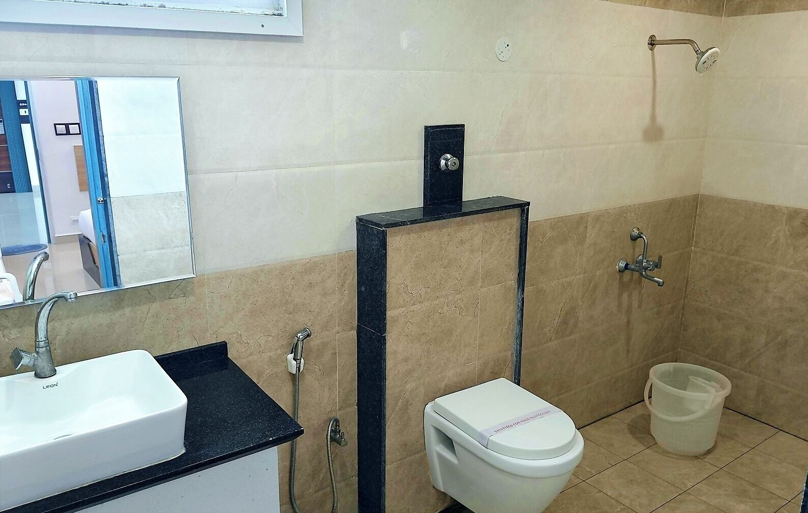 Une salle de bain avec un lavabo blanc, des toilettes et un espace douche.