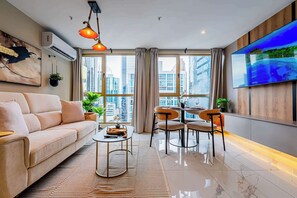 A modern living room with a sofa, coffee table, and dining area.