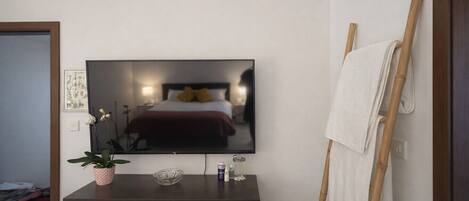 Escritorio, tabla de planchar con plancha, wifi y ropa de cama