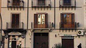A multi-story building with balconies, a storefront named "Spinnato," and a sign for "Edicola" bookstore. - Yourlife Suite1 - Delightful house with  small terrace (Palermo)