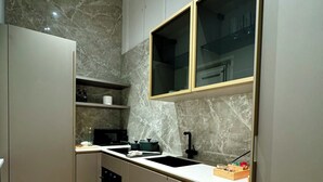 Eine moderne Küche mit Marmorfliesenspiegel, eingebauten Geräten und Holzboden.