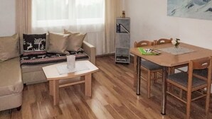 A cozy living room with a sofa, a small table, and a dining table with chairs. - Kristall by Interhome (Prutz/Kaunertal)