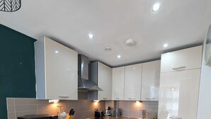Una cocina moderna con una isla central, electrodomésticos de acero inoxidable y armarios blancos.