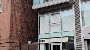 Un edificio moderno con fachada de ladrillo, entrada de vidrio y un letrero que dice 'BLOCK'.